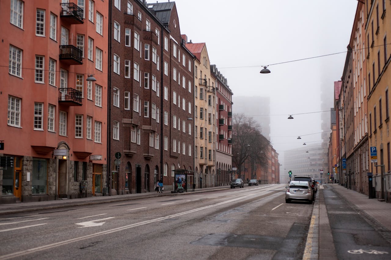 about-us Foggy urban street with colorful buildings in Stockholm, Sweden, showcasing architecture and an empty atmosphere.